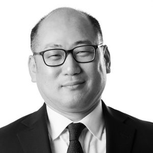 John Yoo, Investment Reporting Associate at Sage Financial Group. Headshot photograph of John Yoo smiling and looking directly at the camera, wearing professional attire.